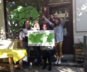 Übergabe des Spendengutscheins an Moabit hilft e.V. durch eine Mitarbeiterin von DeineStadtKlebt.de